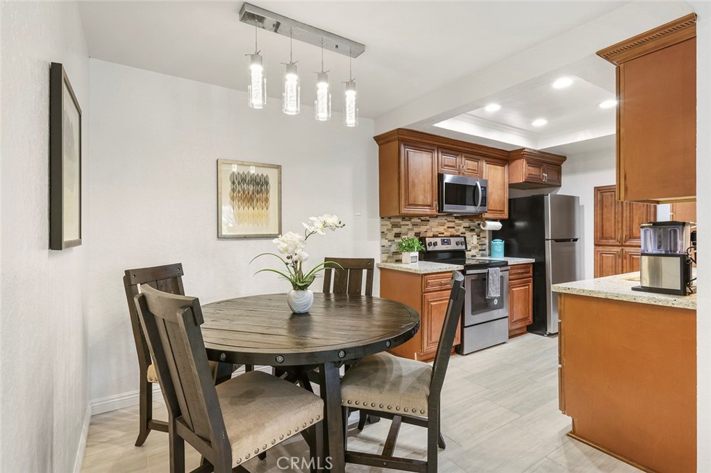 20702 El Toro Road, Unit 226 Lake Forest, CA 92630 - Photo 5 of 39 a kitchen with a dining table and chairs