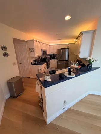 a kitchen with granite countertop a refrigerator stove and sink