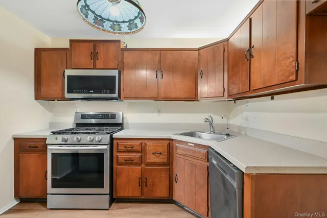 a kitchen with stainless steel appliances a stove a microwave a sink and cabinets