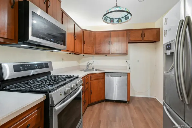 a kitchen with stainless steel appliances granite countertop a stove a refrigerator and a microwave oven