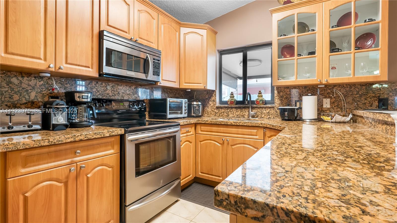 2549 West 72nd Place Hialeah, FL 33016 - Photo 26 of 46 a kitchen with stainless steel appliances granite countertop a stove and cabinets