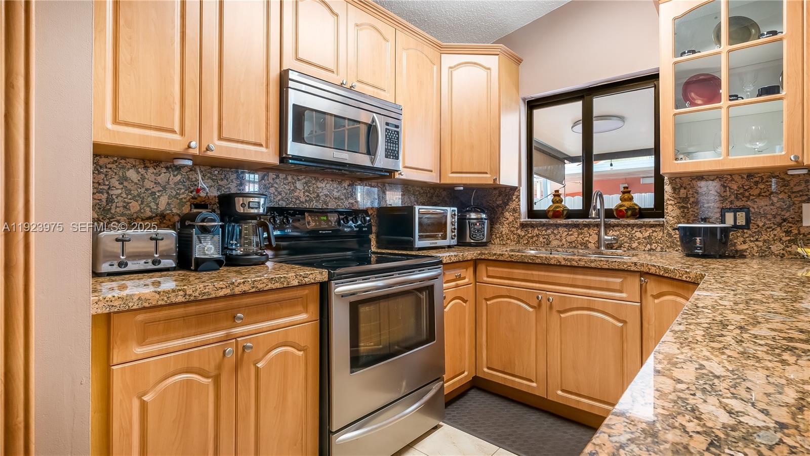 2549 West 72nd Place Hialeah, FL 33016 - Photo 31 of 46 a kitchen with stainless steel appliances granite countertop a stove and a microwave