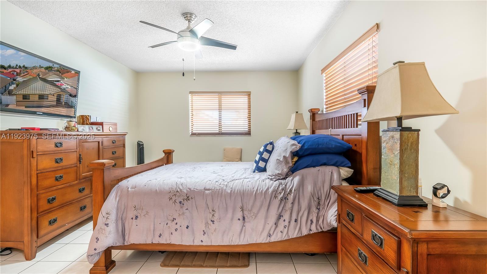 2549 West 72nd Place Hialeah, FL 33016 - Photo 35 of 46 a bedroom with a bed and a chandelier