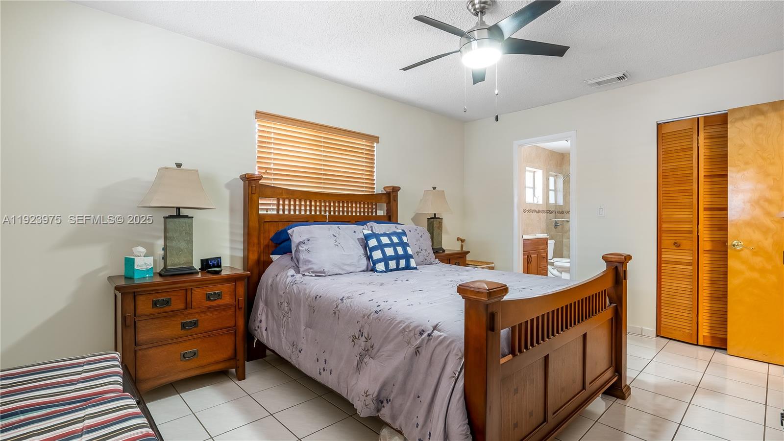 2549 West 72nd Place Hialeah, FL 33016 - Photo 36 of 46 a bedroom with a bed and a chandelier