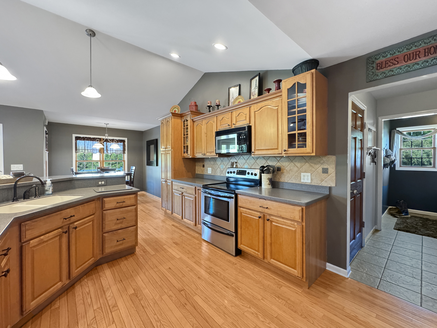 1063 Deer Valley Drive Varna, IL 61375 - Photo 12 of 87 a large kitchen with stainless steel appliances granite countertop a stove top oven a sink dishwasher a dining table and chairs with wooden floor