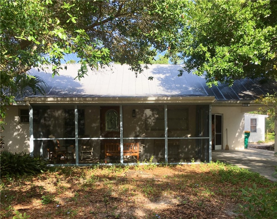 9605 Riverview Drive Micco, FL 32976 - Photo 25 of 36 a view of a backyard with wooden fence and a large tree