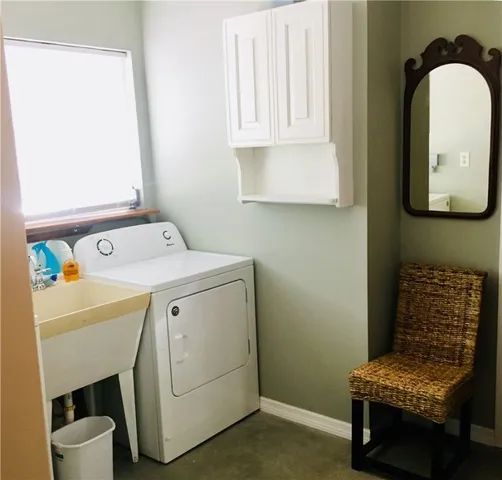 a bedroom with a bed a chandelier and dresser
