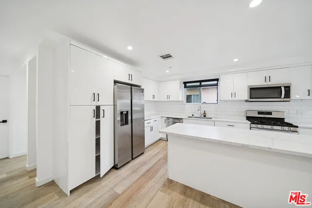 a kitchen with stainless steel appliances a refrigerator stove microwave and sink