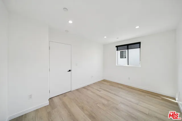 a view of a room with wooden floor and white walls