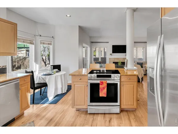 a kitchen with stainless steel appliances a stove a refrigerator sink and a fireplace