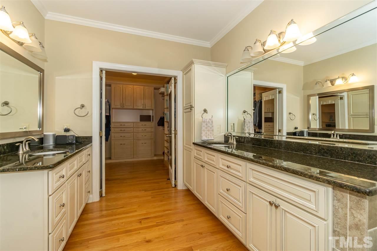 712 Misty Isle Place Raleigh, NC 27615 - Photo 20 of 30 a spacious en suite bathroom with a granite countertop sink mirror and shower