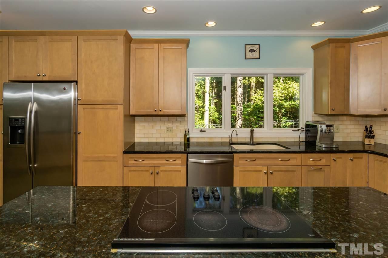 712 Misty Isle Place Raleigh, NC 27615 - Photo 7 of 30 a kitchen with stainless steel appliances granite countertop a stove a sink and a microwave