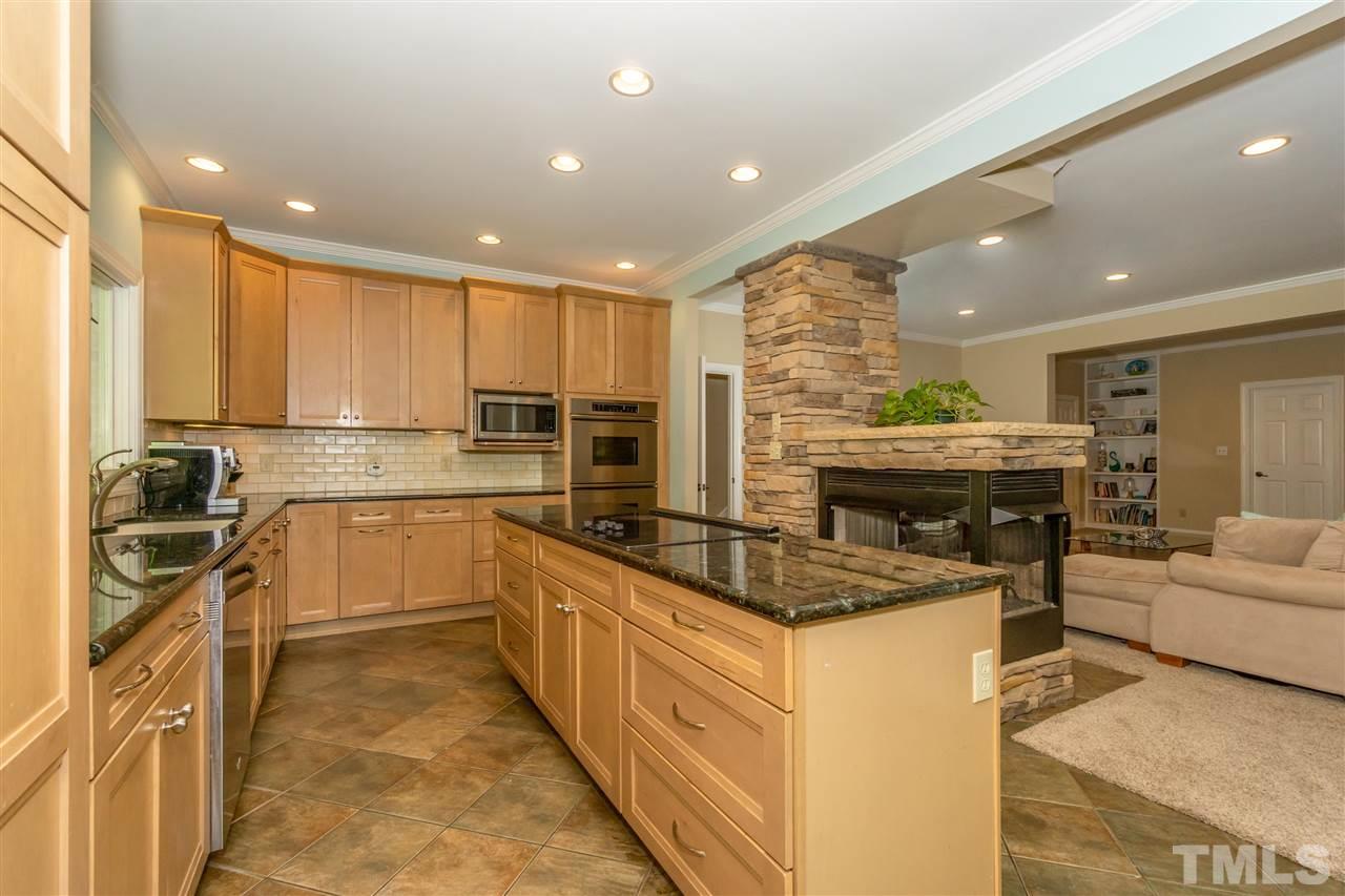 712 Misty Isle Place Raleigh, NC 27615 - Photo 9 of 30 a kitchen with stainless steel appliances granite countertop a stove top oven a sink dishwasher a dining table and chairs with wooden floor