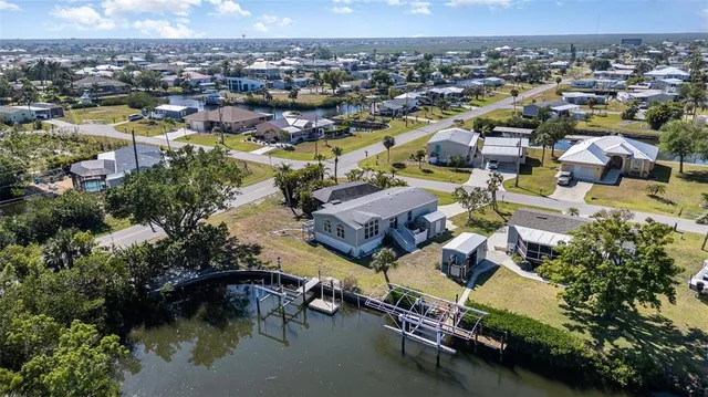 an aerial view of residential houses with outdoor space and trees