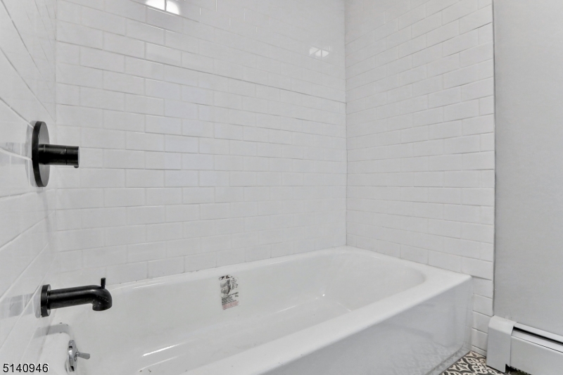 25 Kiel Avenue, Unit 1 Butler, NJ 07405 - Photo 9 of 13 a bathroom with a bathtub