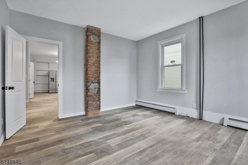 25 Kiel Avenue, Unit 1 Butler, NJ 07405 - Photo 10 of 13 wooden floor in an empty room with a window