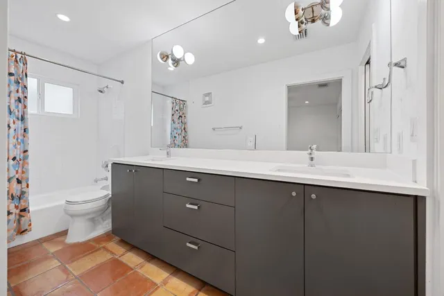 a bathroom with a double vanity sink mirror and toilet