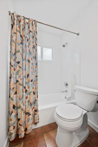 a bathroom with a toilet and a shower curtain