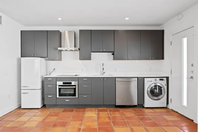 a kitchen with stainless steel appliances granite countertop a stove a microwave and a refrigerator