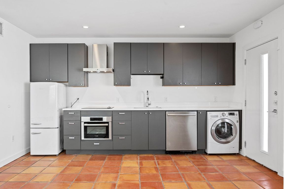 1200 Enfield Road, Unit 107 Austin, TX 78703 - Photo 5 of 21 a kitchen with stainless steel appliances granite countertop a stove a microwave and a refrigerator