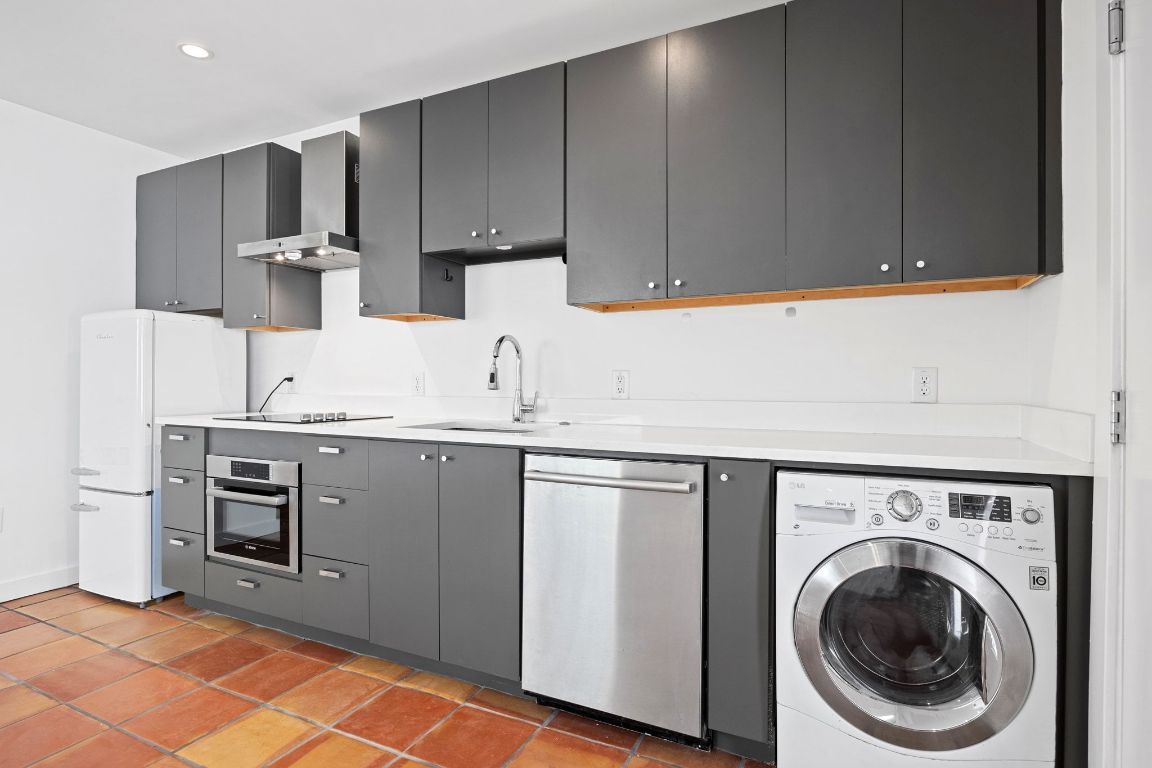 1200 Enfield Road, Unit 107 Austin, TX 78703 - Photo 7 of 21 a kitchen with stainless steel appliances granite countertop a sink and cabinets