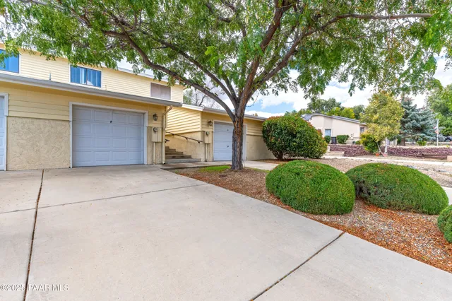 a view of a house with a yard and large tree