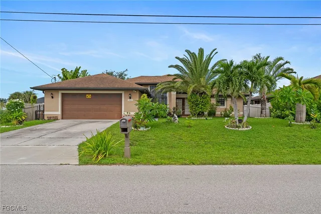 a view of a house with a small yard and palm trees