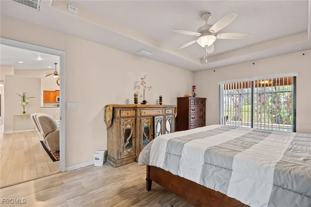 a spacious bedroom with a bed a dresser and a large window