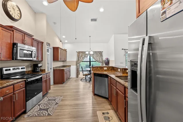 a kitchen with stainless steel appliances granite countertop a stove top oven a refrigerator a sink and dishwasher