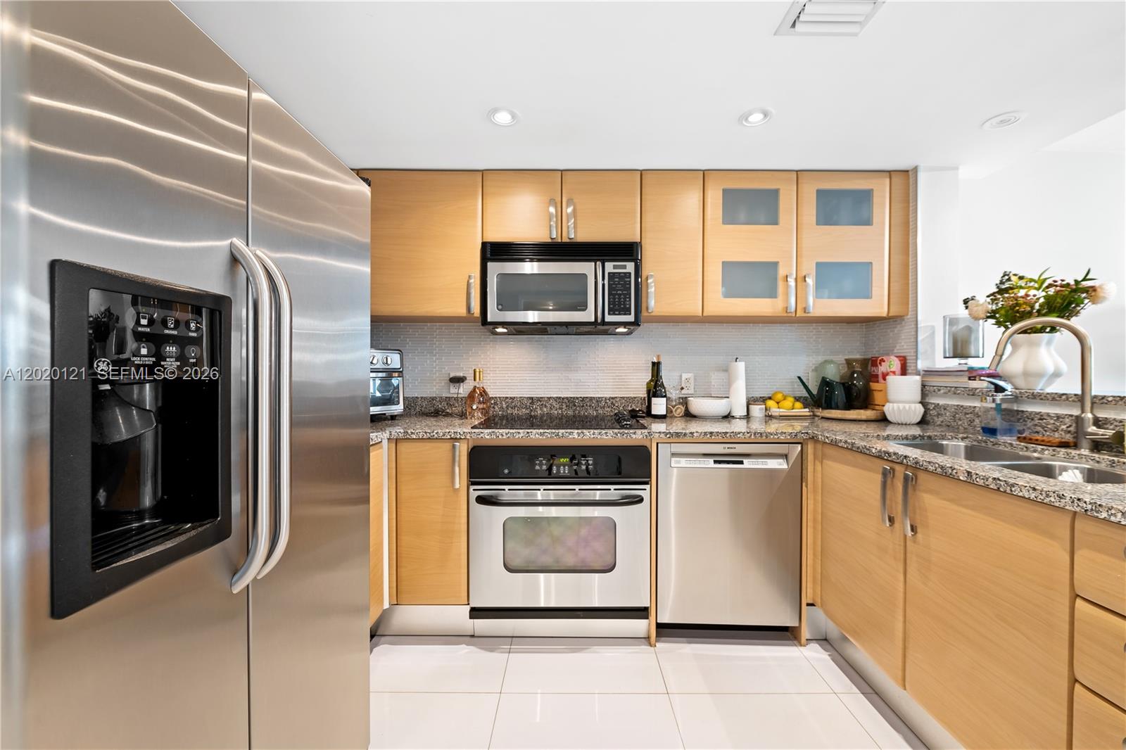 2101 Brickell Avenue, Unit 1909 Miami, FL 33129 - Photo 9 of 25 a kitchen with stainless steel appliances granite countertop a stove a sink and a microwave