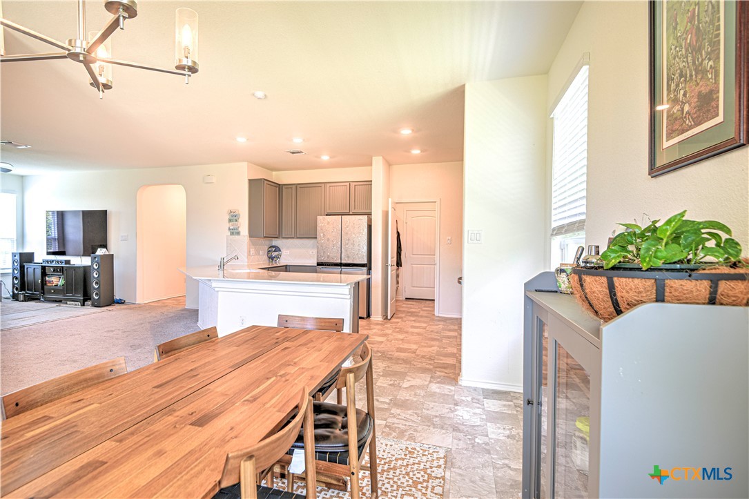 119 Lucky Texan Cove Jarrell, TX 76537 - Photo 14 of 33 a dining hall with stainless steel appliances kitchen island granite countertop a table and chairs in it