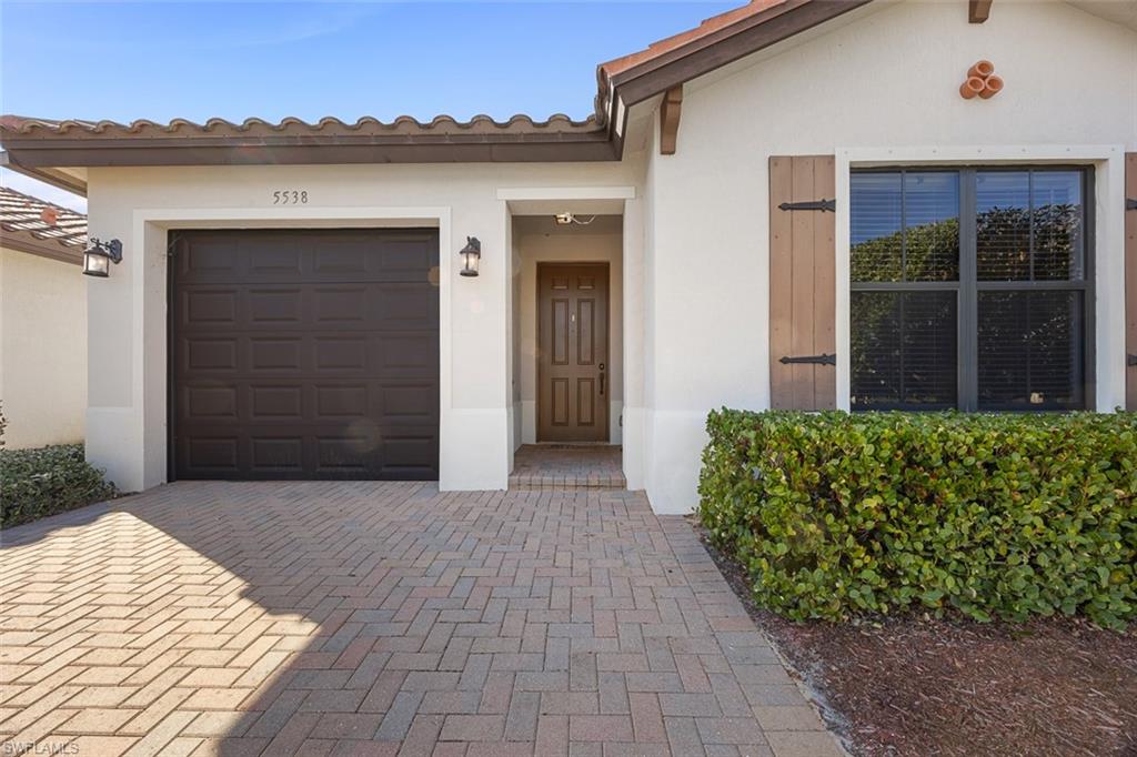 5538 Useppa Drive Ave Maria, FL 34142 - Photo 2 of 35 front view of a house with a garden