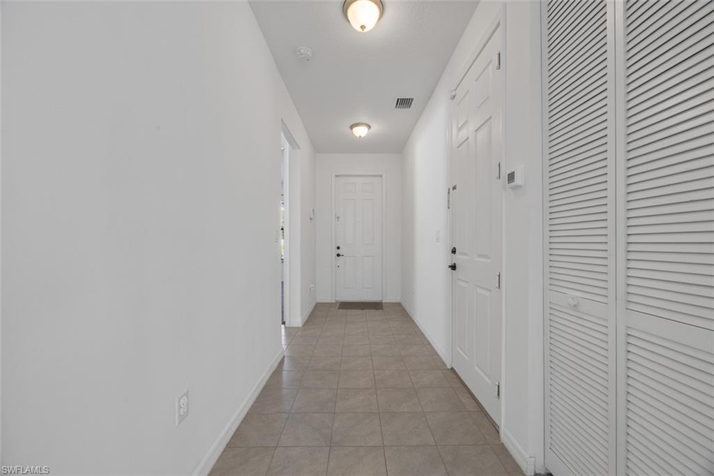 5538 Useppa Drive Ave Maria, FL 34142 - Photo 6 of 35 a view of a hallway with wooden shelves