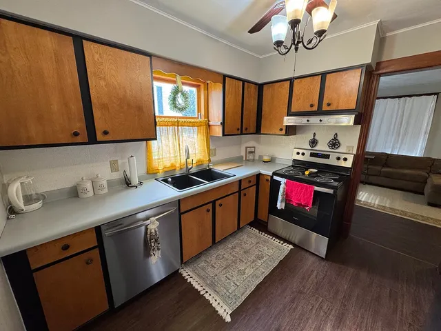 a kitchen with granite countertop a sink window and cabinets