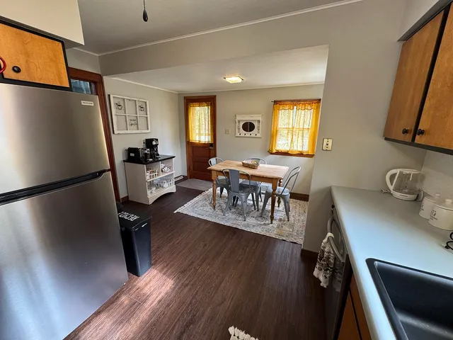 a view of a dining room with furniture a rug and wooden floor