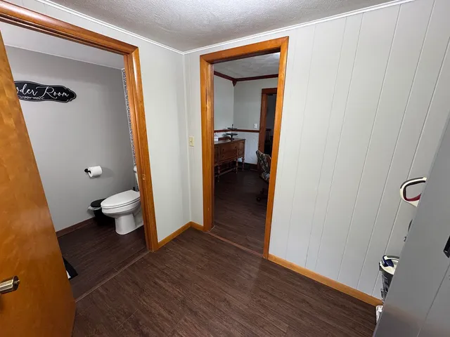 a bathroom with a toilet and a wooden floor