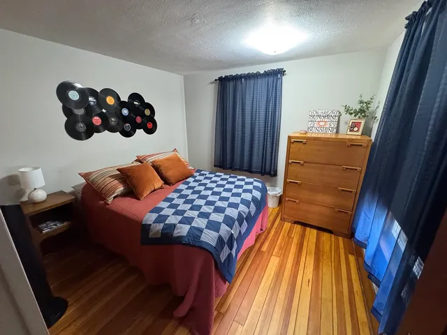 a bedroom with a bed and wooden floor