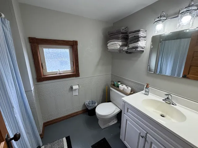 a bathroom with a sink mirror and toilet