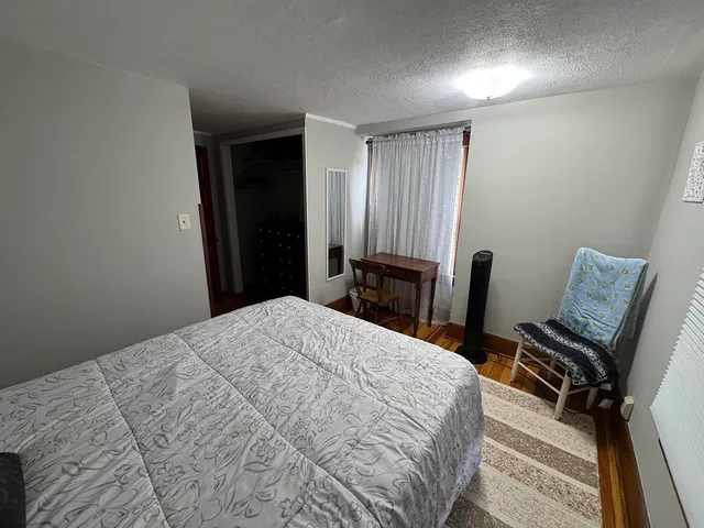 a bed sitting in a bedroom next to a window