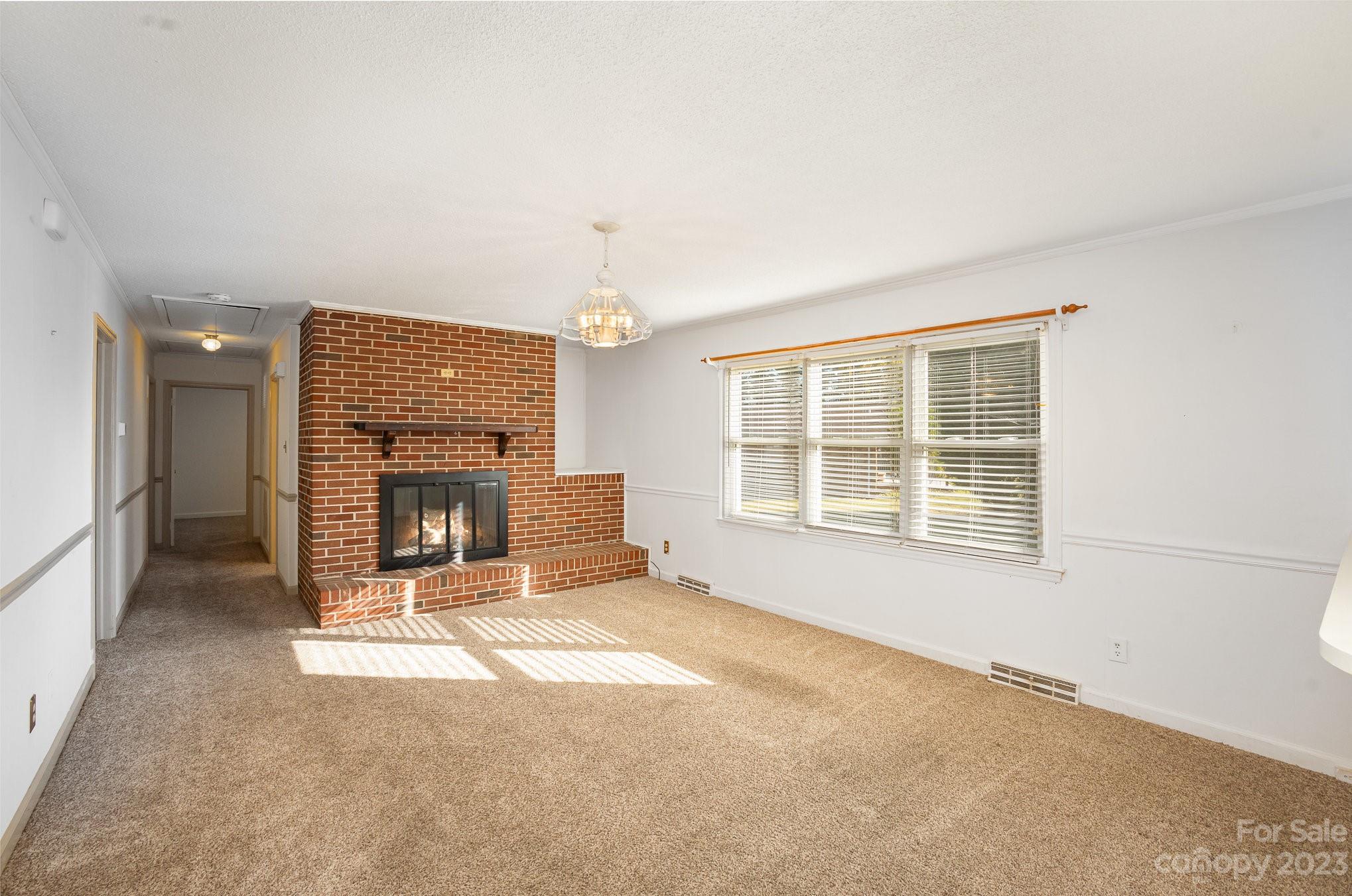 408 Jane Street Cherryville, NC 28021 - Photo 5 of 15 an empty room with a fireplace and windows