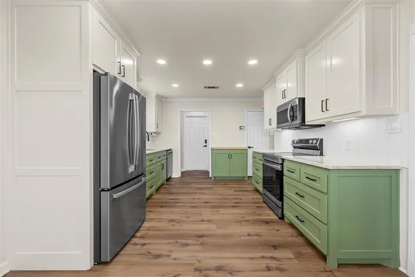a kitchen with stainless steel appliances granite countertop a refrigerator and a sink