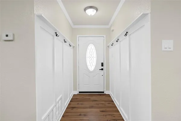 a view of a hallway with wooden floor and entryway