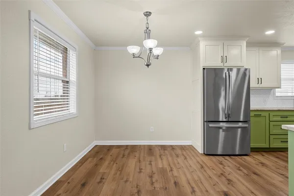 a kitchen with a refrigerator and wooden floor