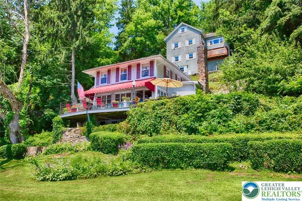 an aerial view of a house with a big yard and large trees