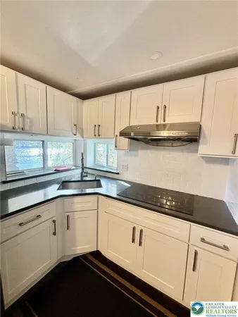a kitchen with granite countertop stainless steel appliances a counter top space and cabinets