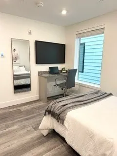a bedroom with a bed and a flat screen tv