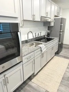 a kitchen with stainless steel appliances granite countertop a sink and a stove