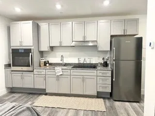 a kitchen with stainless steel appliances granite countertop a refrigerator sink and cabinets