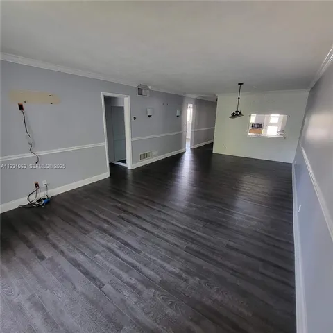 a view of a livingroom with wooden floor and lounge chair