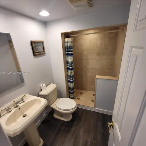 a bathroom with a sink a toilet and shower
